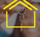 Close-up of hands holding house keys with yellow house icon overlay, representing real estate.